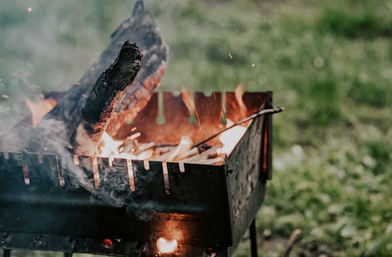 a hand holding a knife over a fire